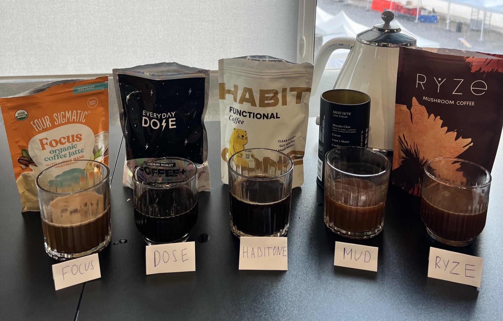 Five mushroom coffee brands lined up for a taste test — Four Sigmatic, Everyday Dose, Habitone, MUD\WTR and Ryze